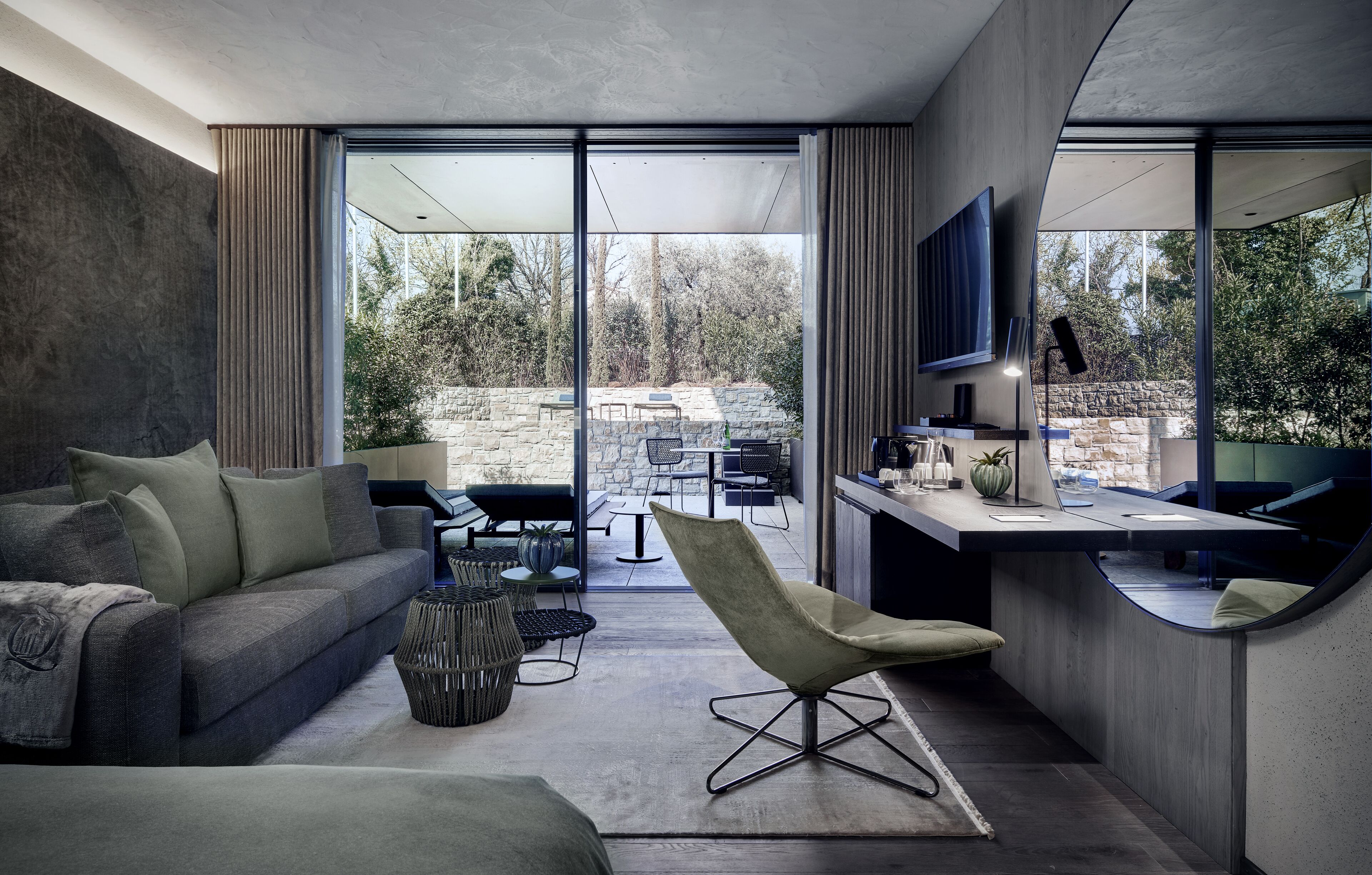 Un salon moderne comprenant un canapé, un fauteuil et un coin repas avec une table et des chaises.