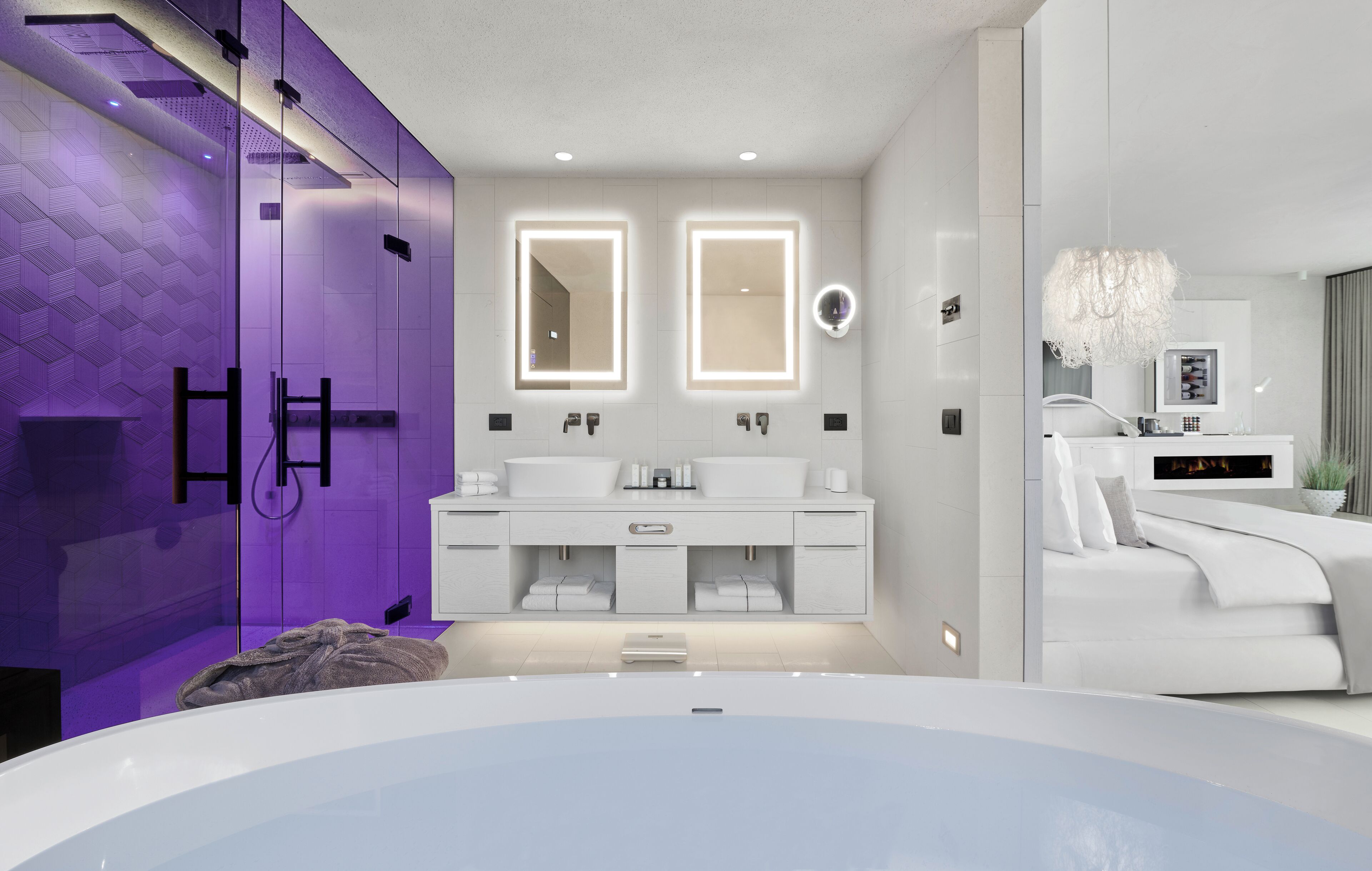 Ein modernes Badezimmer mit einer großen Badewanne, zwei Waschbecken und einem Waschtisch mit Spiegel.