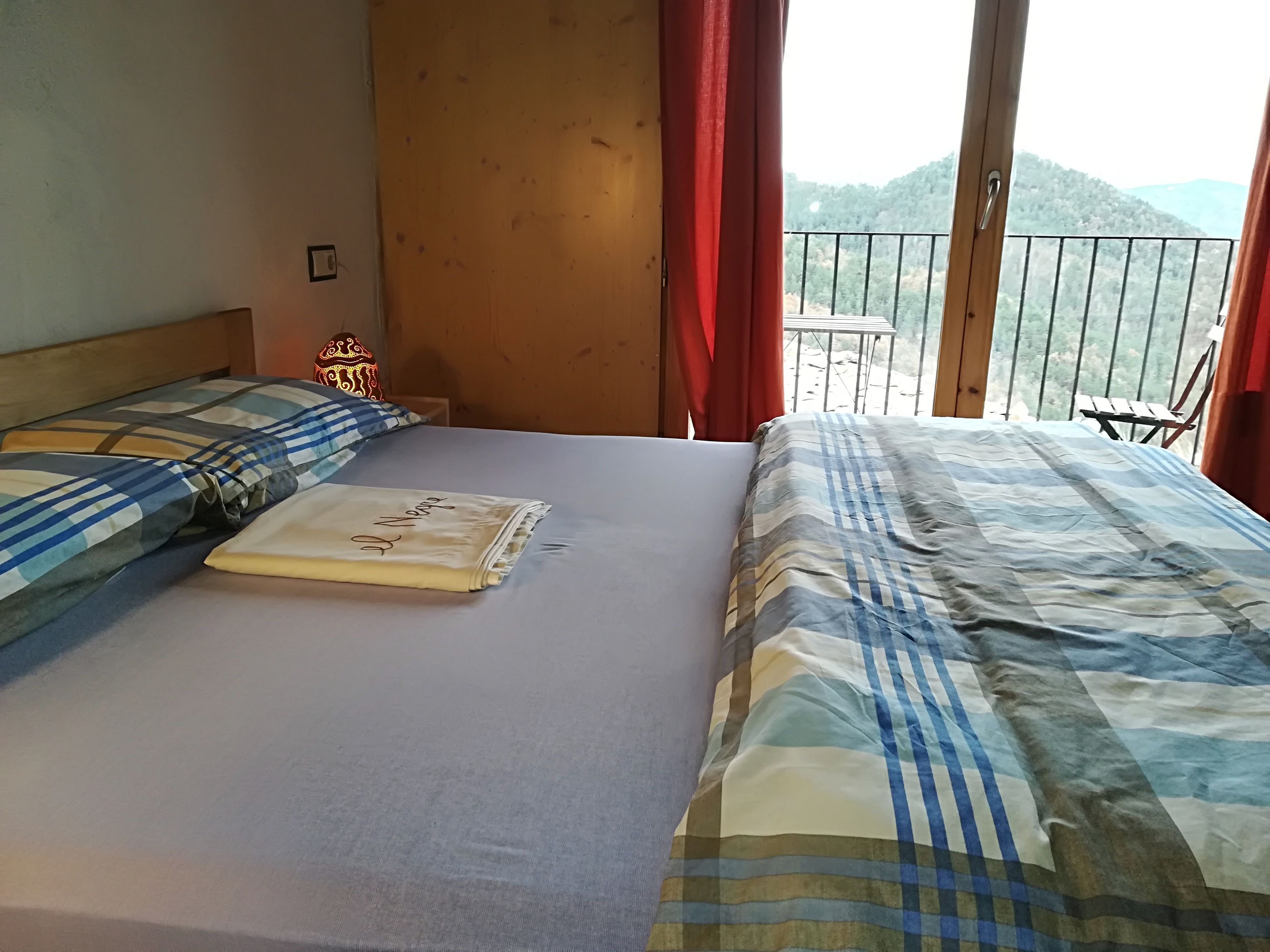A hotel room with a bed, a table, and a view of the mountains.