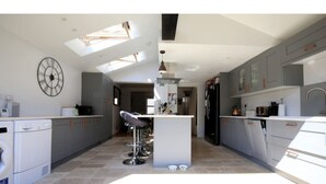 A modern kitchen with a central island, grey cabinets, and a skylight. - Modern, Chic 2BR Townhouse in Central Oxford (Oxford)
