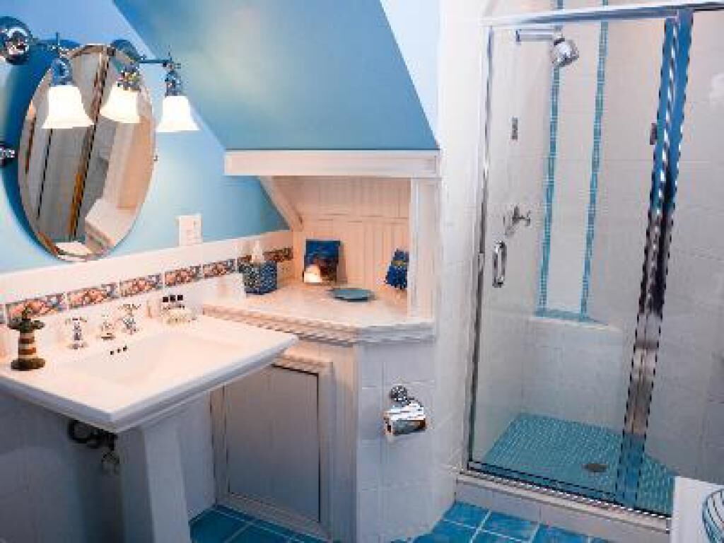 A bathroom with a shower, a sink, and a mirror.