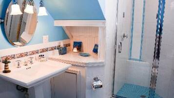 Ein Badezimmer mit Dusche, Waschbecken und Spiegel.
