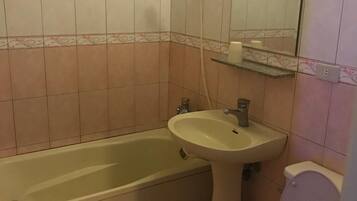A bathroom with a bathtub, sink, and toilet.