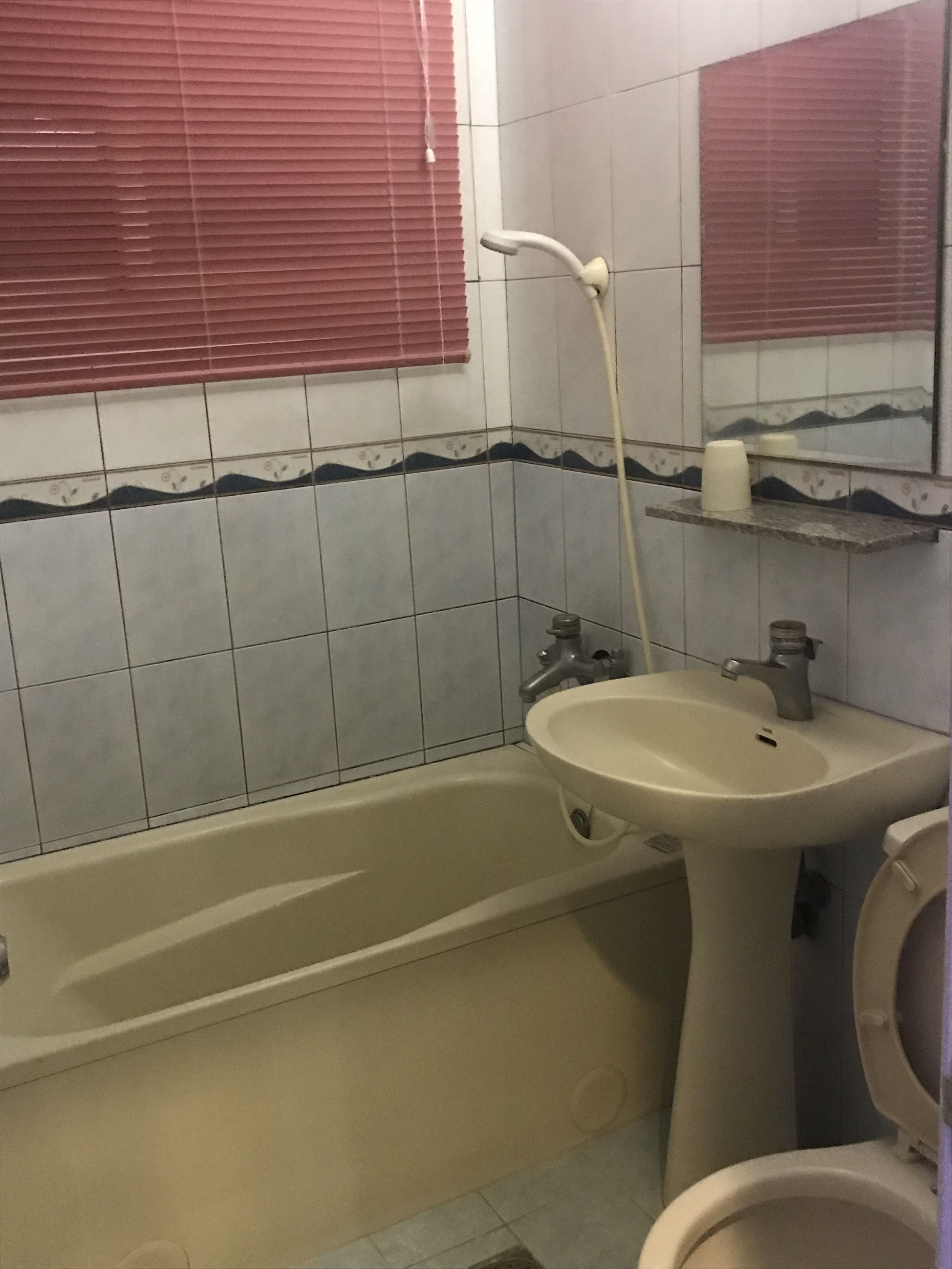 A bathroom with a bathtub, sink, and toilet.