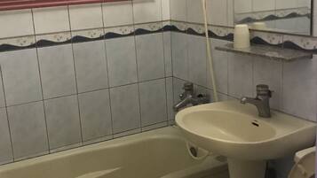 A bathroom with a bathtub, sink, and toilet.