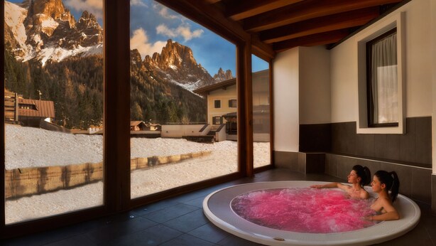 Un espace spa doté d’un bain à remous et offrant une vue sur les montagnes.