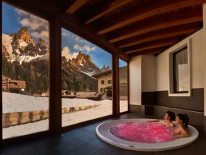 Un espace spa doté d’un bain à remous et offrant une vue sur les montagnes.