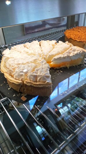 Tarta de manzana con crema batida sobre una rejilla metálica.