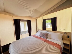 Un dormitorio con cama, cortinas, una ventana y cabecera de madera.