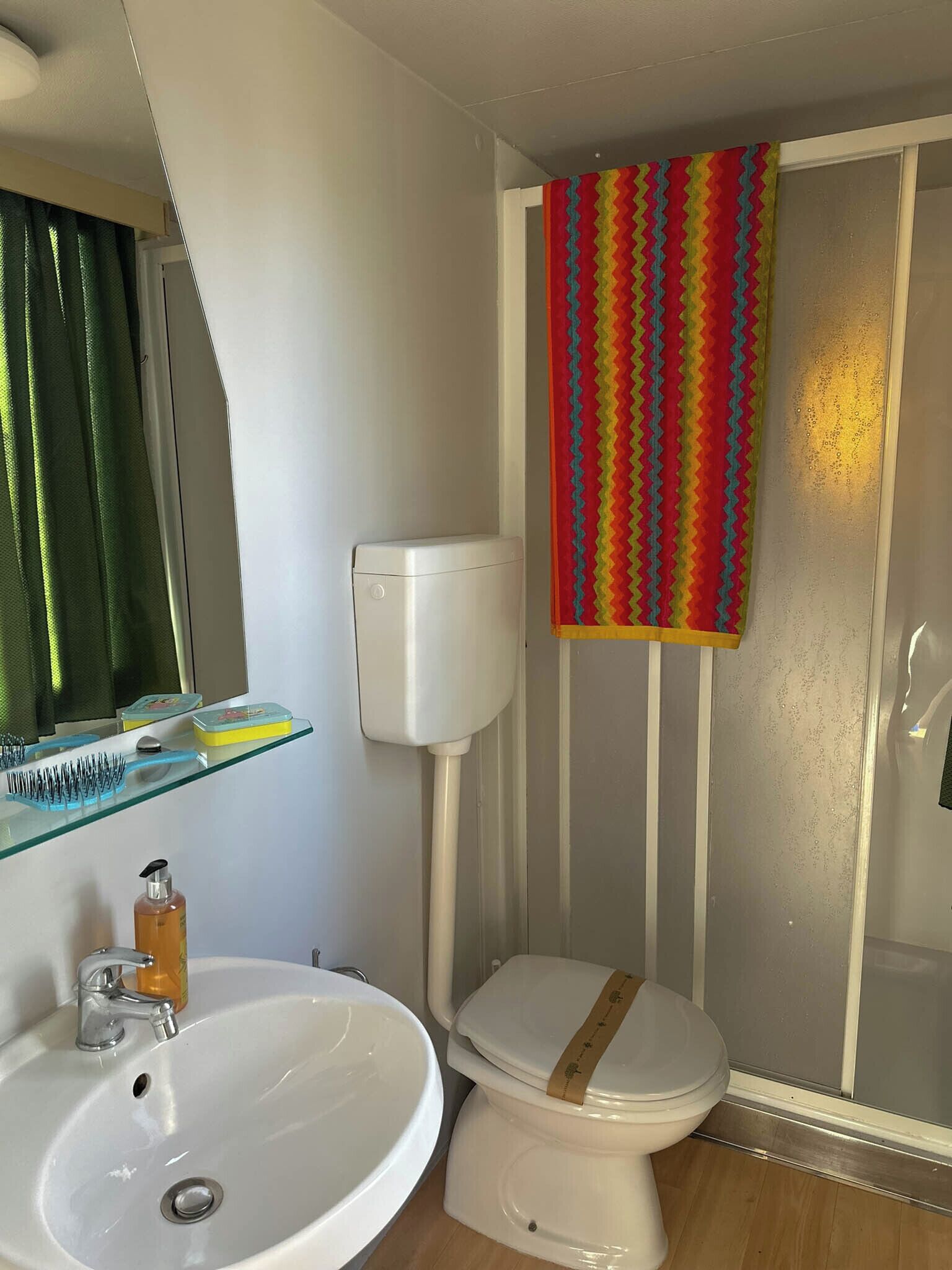 A bathroom with a white sink, a toilet, and a shower enclosure.