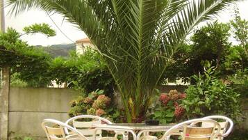 A table with four chairs in a garden setting.