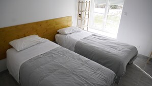 A room with two single beds, a wooden headboard, and a window with blinds. - Chez Mary (Vanosc)