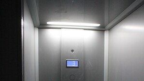 An elevator with a digital display, control panel, and a phone. - Chez Mary (Vanosc)