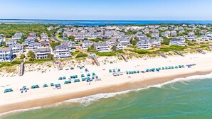 A coastal residential area with beachfront properties, a sandy beach, and a clear blue sky. - Ocean Front, Elevator, Pool, Hot Tub, Gated community and amazing views! BI-38 (Corolla)