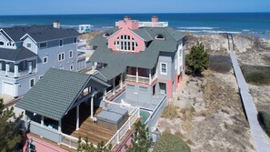A coastal property with multiple buildings, a wooden deck, and a view of the ocean.