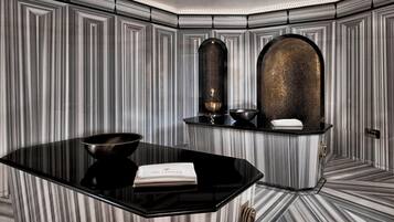Experience a visually striking bathroom with a geometric pattern, sleek countertop, and minimalist design.