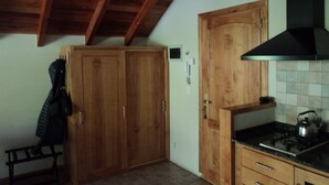 Cucina con mobili in legno, una panca e un fornello.
