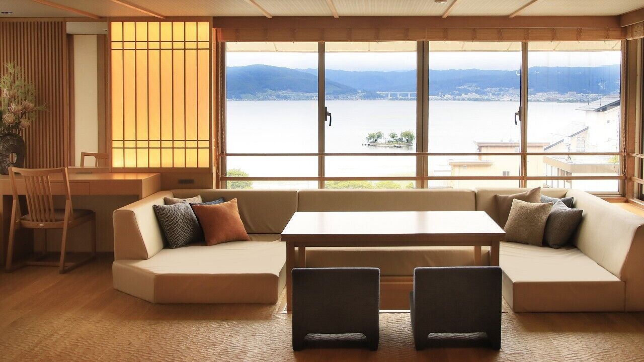 Una habitación con un ventanal grande, un sofá, una mesa y una silla.