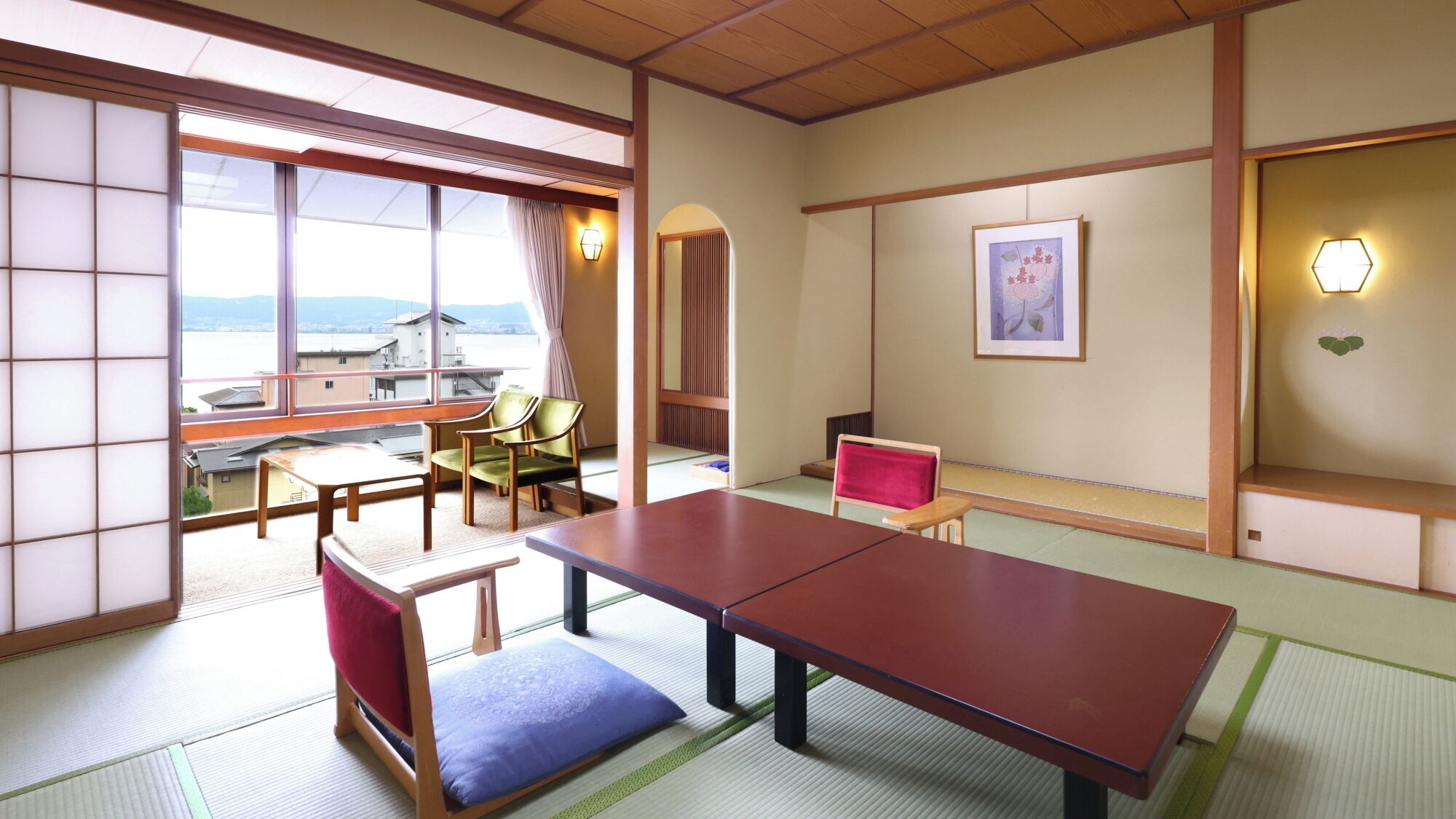 Una habitación japonesa tradicional con suelo de tatami, una mesa baja, sillas y vistas a través de amplias ventanas.