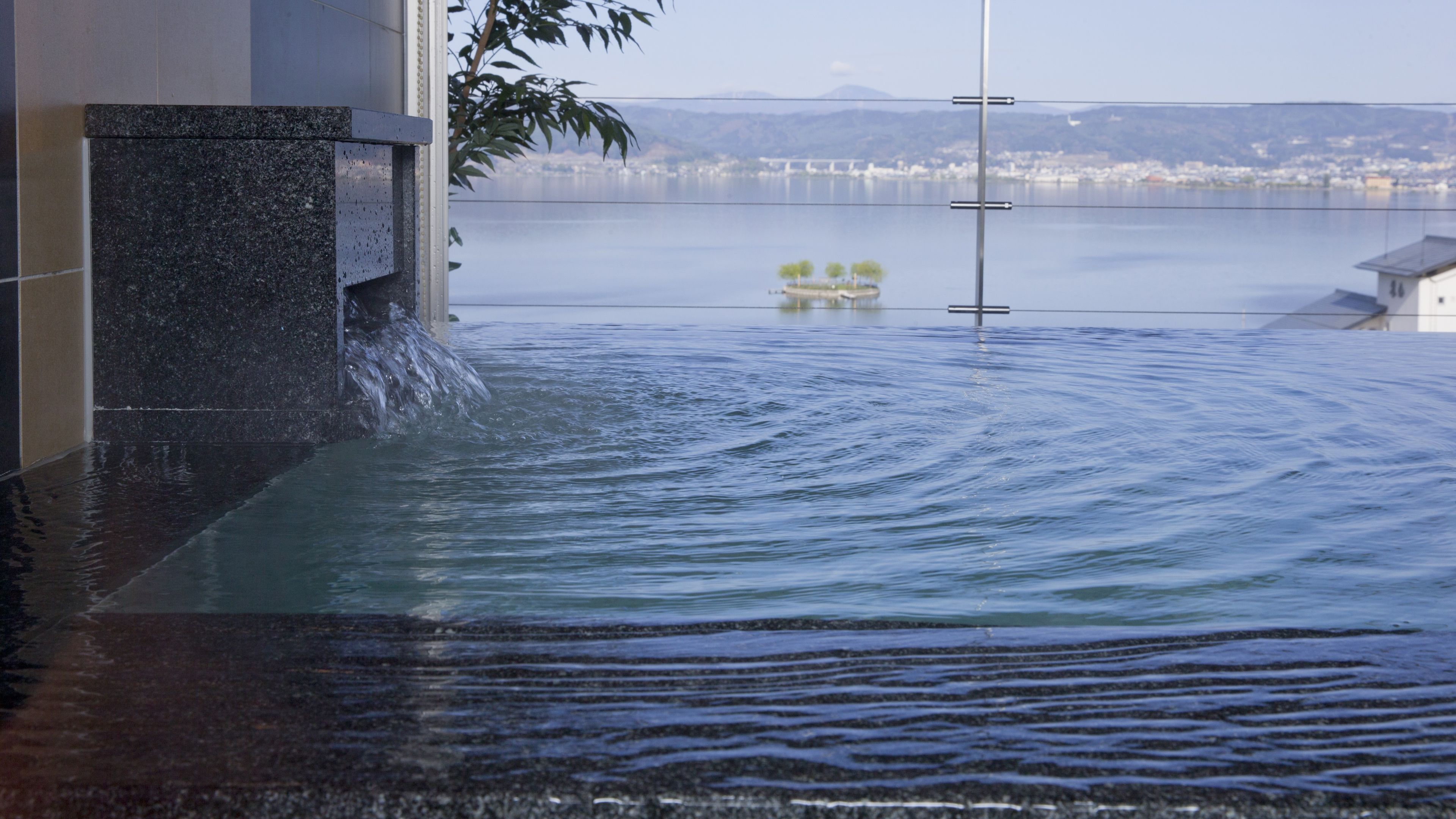 Zona inundada con agua cubriendo una estructura, un puente al fondo y vista de un paisaje urbano distante.