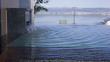 Zona inundada con agua cubriendo una estructura, un puente al fondo y vista de un paisaje urbano distante.