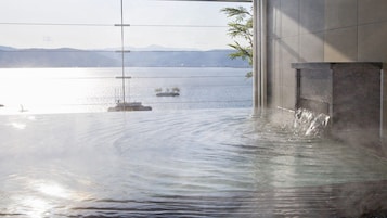 A hot spring area with a view of a body of water and distant mountains.