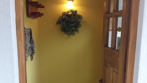 Ein Flur mit einer Holztür, einer Wandleuchte und einem dekorativen Kranz.