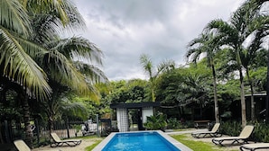 A rectangular swimming pool with a patterned edge, surrounded by grass and palm trees. - Bacalar 102 Hotel (Bacalar)