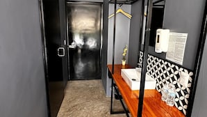 A modern bathroom with a wooden vanity, a mirror, and a black and white patterned wall. - Bacalar 102 Hotel (Bacalar)