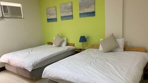 A room with two single beds, a small table with a lamp, and three paintings on the wall. - Luyu Homestay (Lukang)