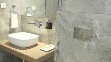 Un baño moderno con un lavamanos grande de mármol, un inodoro y un perchero para toallas.