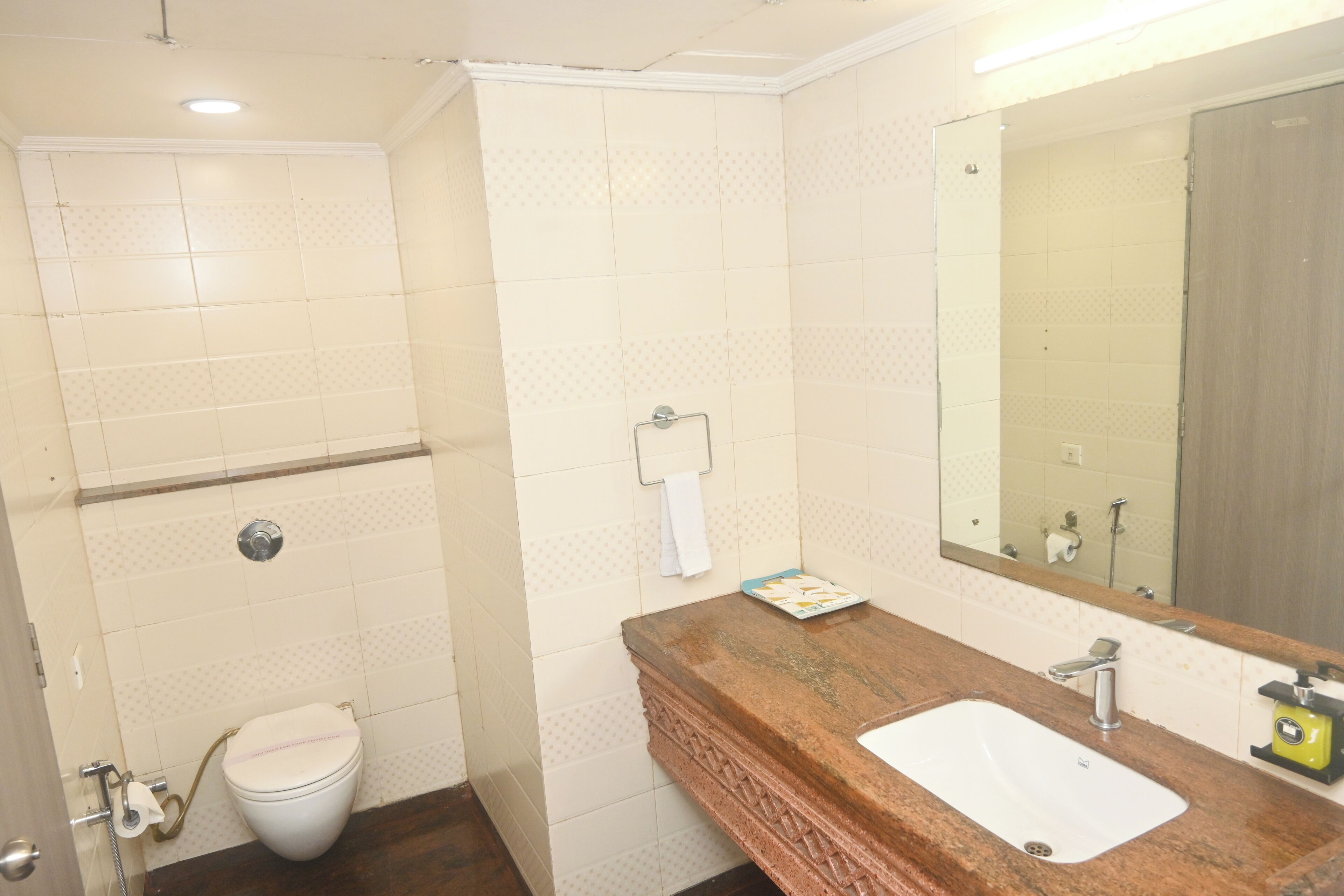 Een badkamer met toilet, wastafel, spiegel en douche.