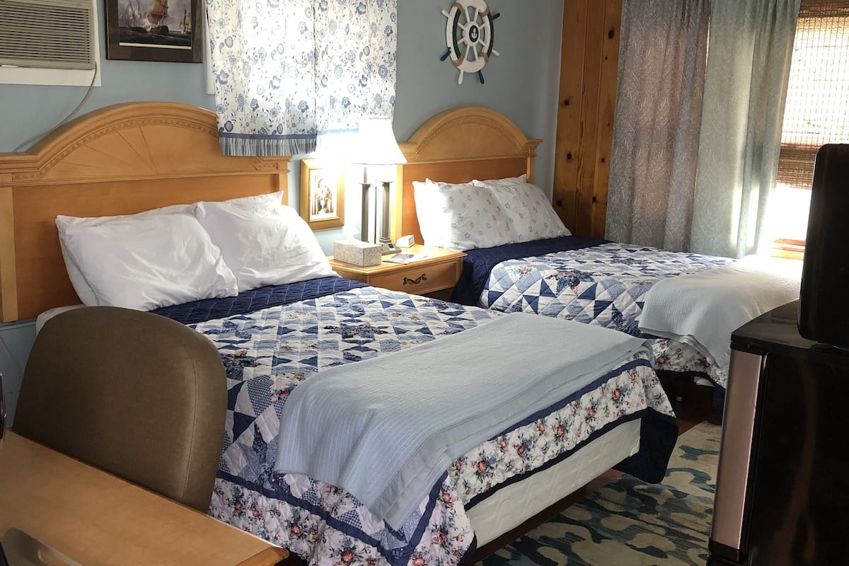 Een hotelkamer met twee bedden, een bureau en een televisie.