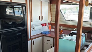 Une petite cuisine équipée d’une cuisinière, d’un four et d’un petit évier.