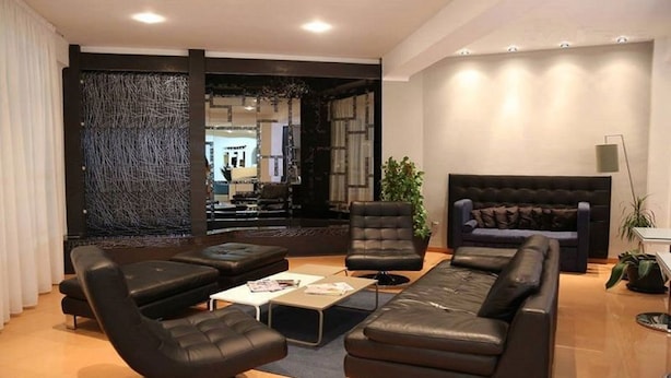 Una sala de estar moderna con un sofá seccional, dos sillones, una mesa de centro y un amplio ventanal.