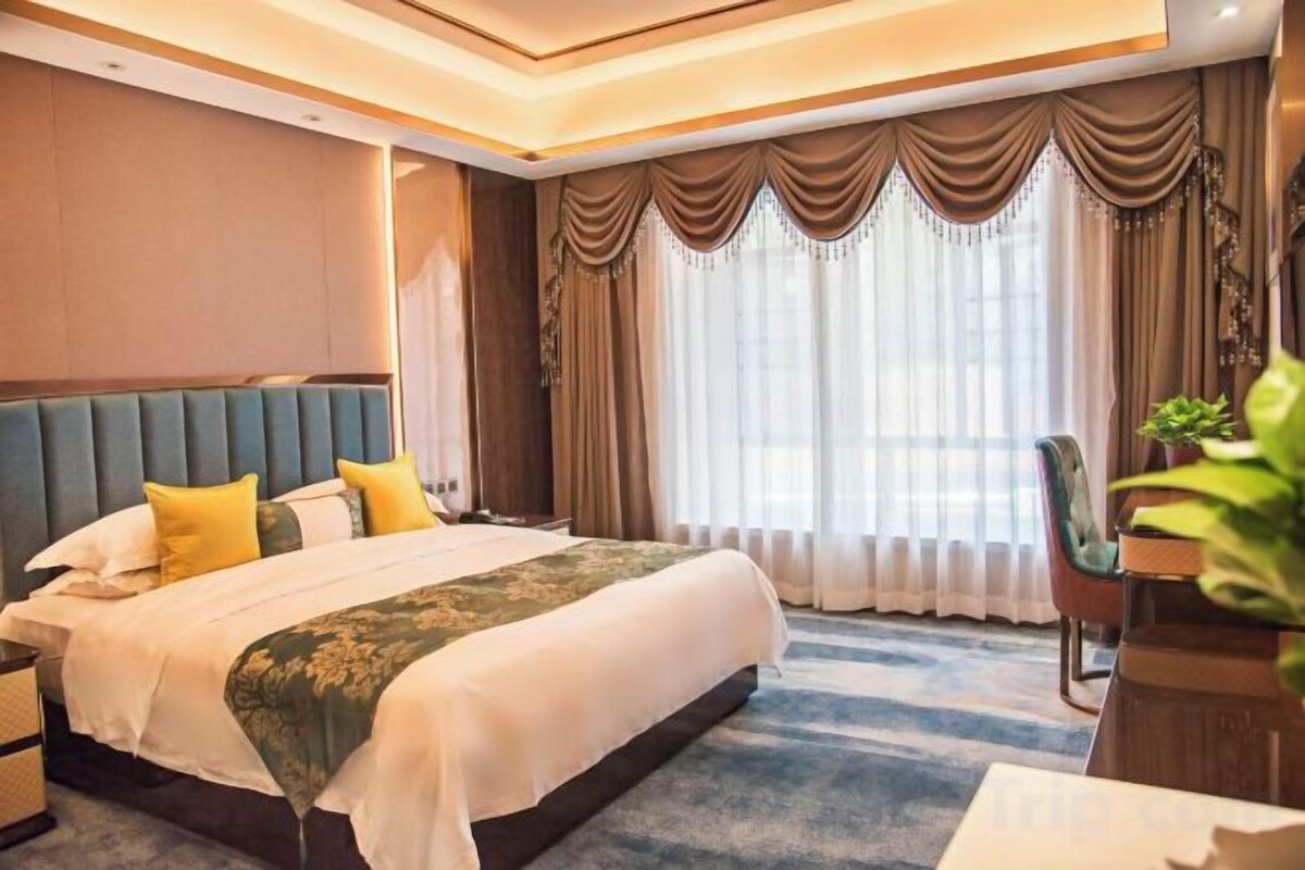 Una habitación de hotel con una cama grande, una mesita de noche, un escritorio y una silla.