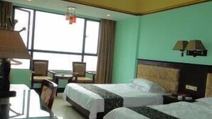 Une chambre d’hôtel avec deux lits, un bureau et une chaise.
