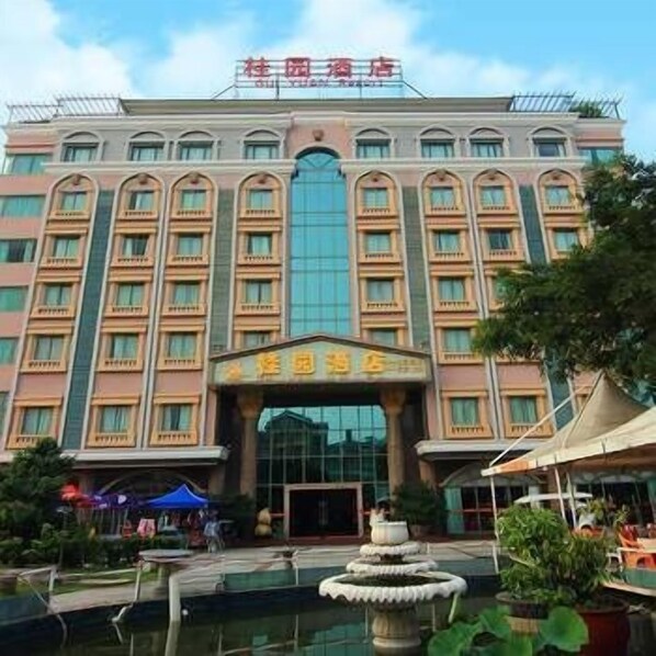 A hotel with a central entrance, multiple floors, and a large glass facade.