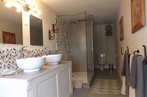 Une salle de bain avec deux lavabos, une douche et des toilettes.