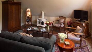 Una sala de estar acogedora con sofá, sillones, una mesita de centro, chimenea, televisor y aparador.