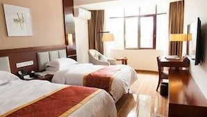 A hotel room with two beds, a desk, a chair, a TV, and a window with curtains. - Lanyang Geology Hot Spring Resort (Danzhou)