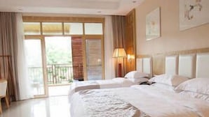 A hotel room with a large bed, a nightstand, a lamp, and a view of the outdoors through a sliding door. - Lanyang Geology Hot Spring Resort (Danzhou)