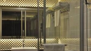 A modern bathroom with a glass shower enclosure, a white sink, and a bathtub. - Guifeng Hotel (Jiangmen)