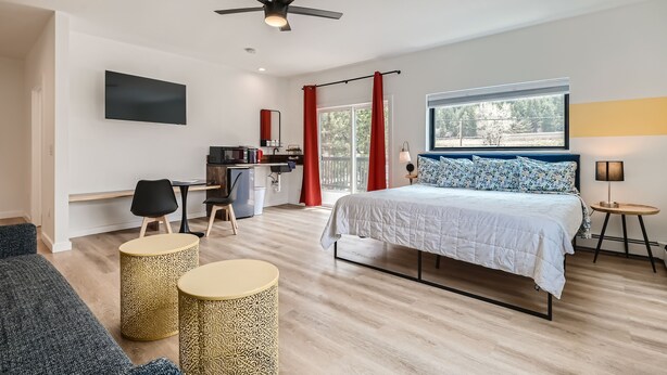A modern bedroom with a bed, desk, and seating area. - Uplift Inn (Idaho Springs)