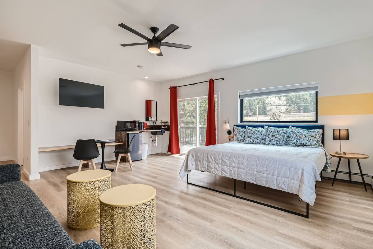 Ein modernes Schlafzimmer mit Bett, Schreibtisch und Sitzecke.