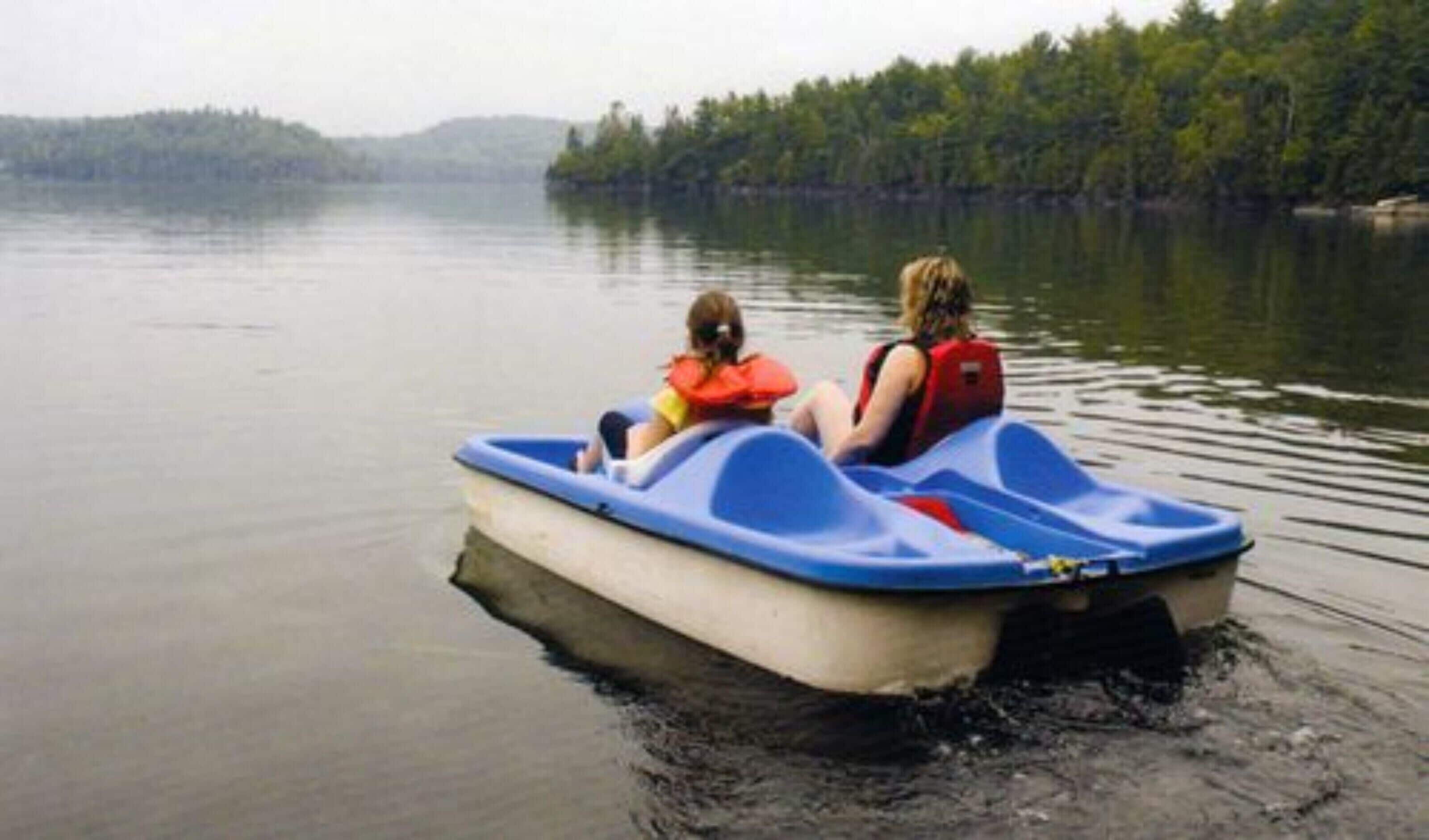 A small, single-person inflatable boat on calm water.