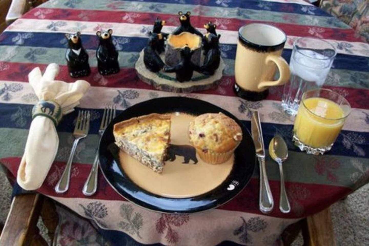 A table set with a plate of food, a mug, a glass of juice, and a fork.