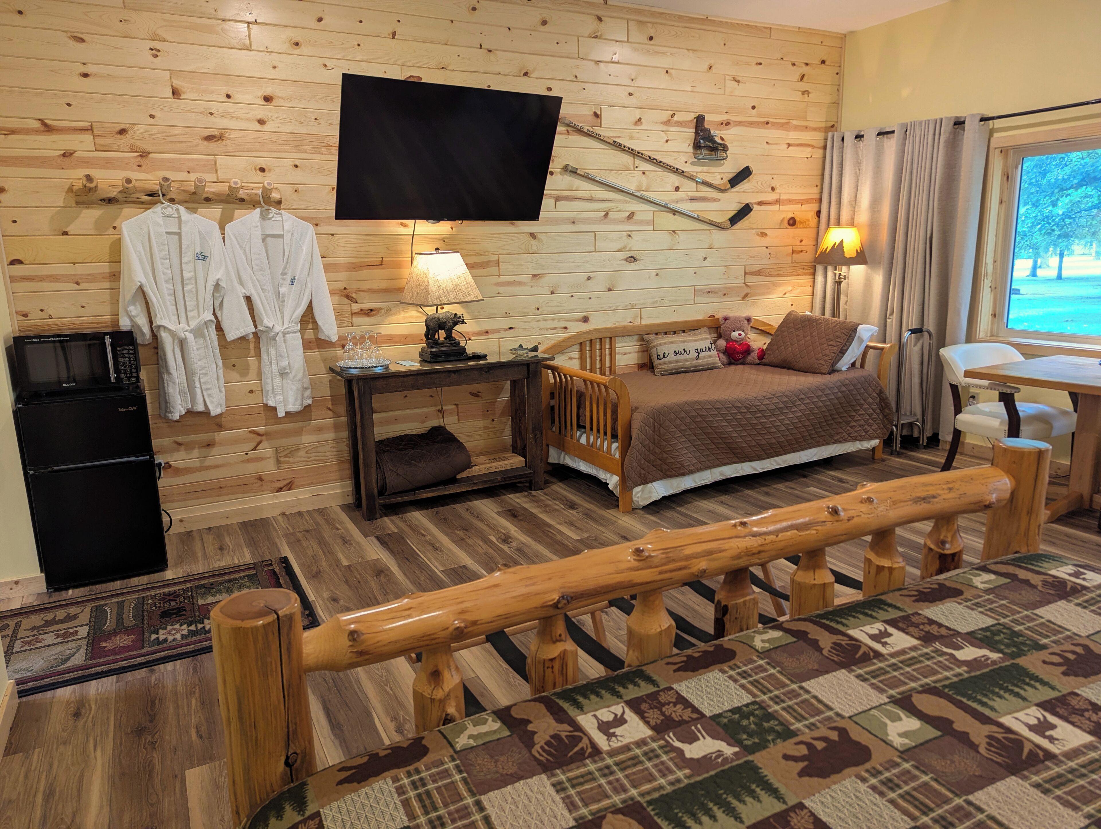 Une pièce confortable avec un lit, un bureau, une télévision et une cheminée.
