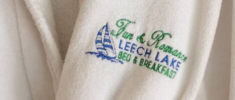 A white towel with embroidered text and a sailboat design.