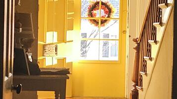 A wooden staircase leading to a yellow door with a wreath.